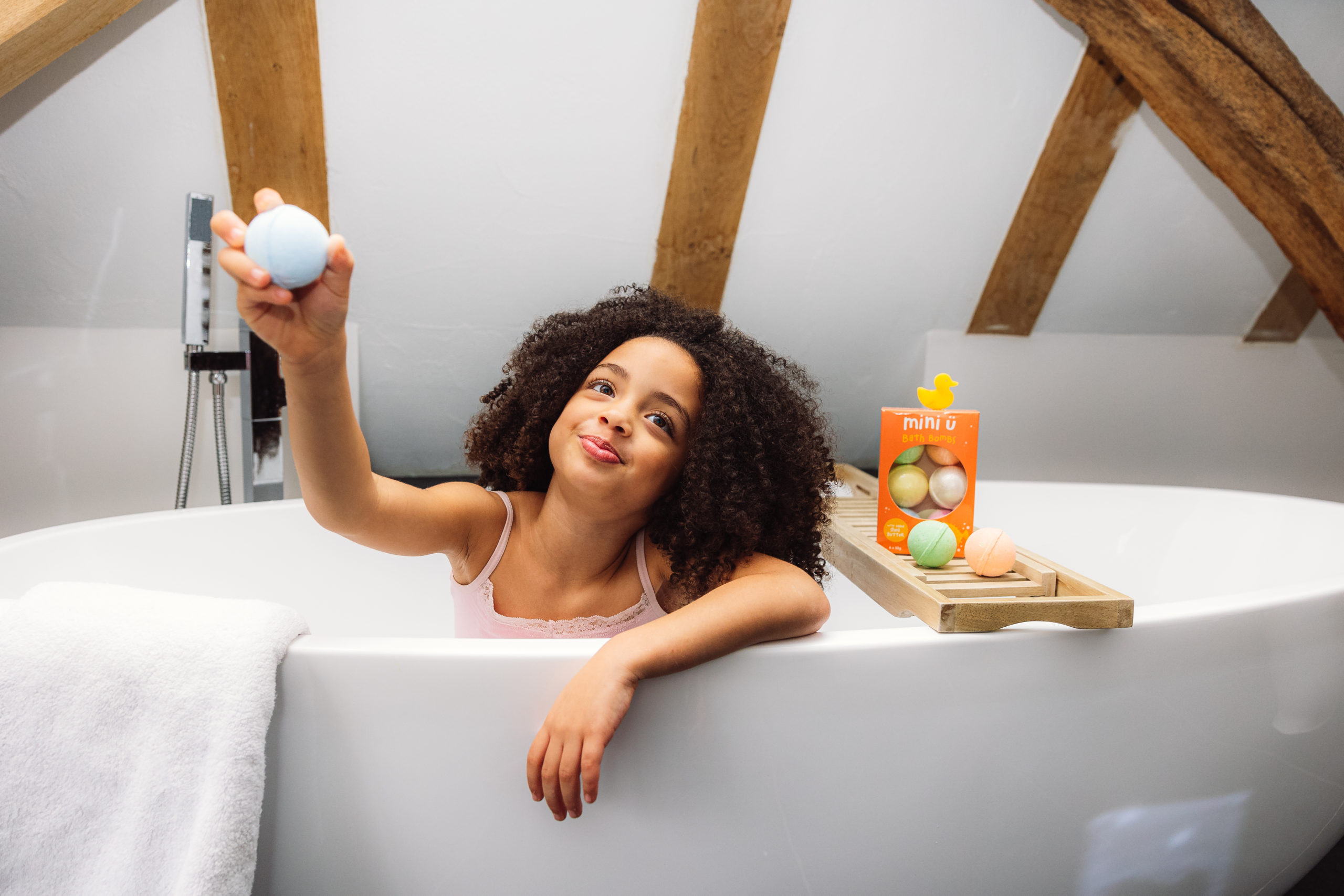 young girl with bath bomb in bath